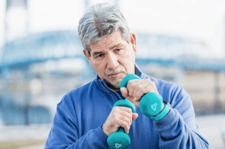 A senior man exercising with two small dumbbells in his hands.