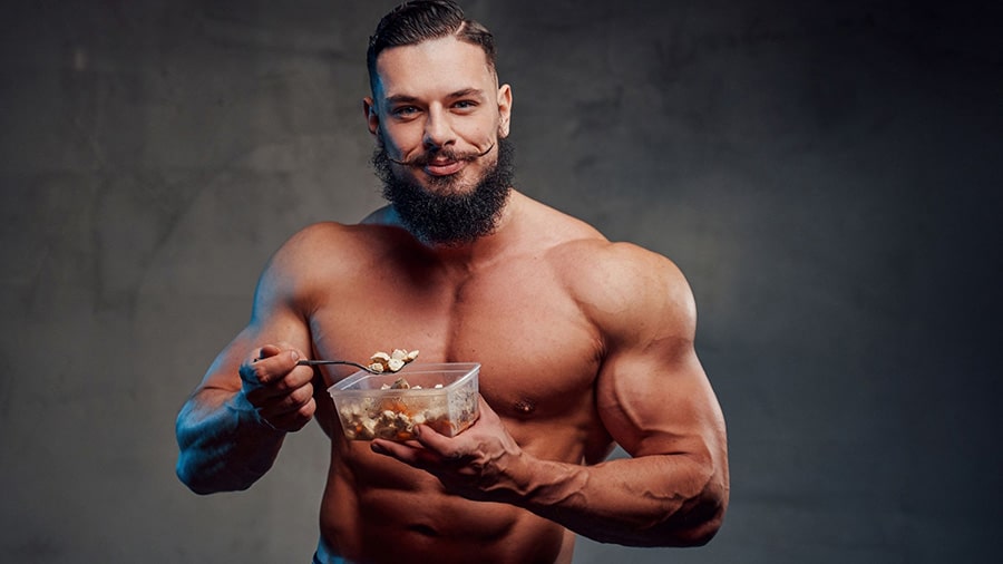 Muscular man eating a meal