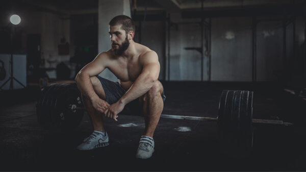 Un pratiquant de musculation observe un temps de repos après un exercice.