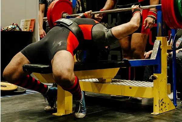 Un pratiquant de powerlifting fait du développé couché avec une barre de musculation.
