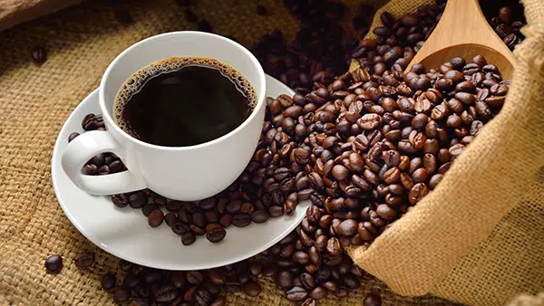 Une tasse de café avec un sac de grains de café ouvert.