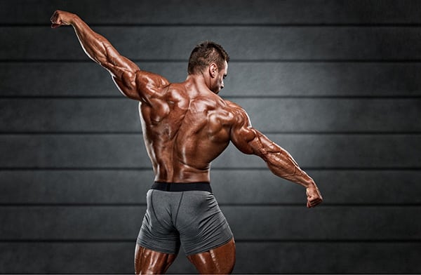 A bodybuilder posing from behind, muscles visible.