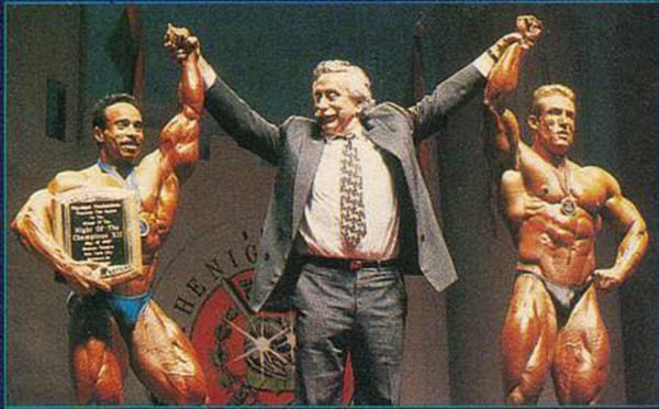 Momo Benaziza on a podium, declared winner of a bodybuilding competition by the famous Joe Weider.