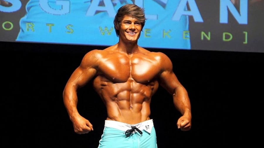Jeff Seid torse nu en train de poser sur la scène d'un concours professionnel de bodybuilding.