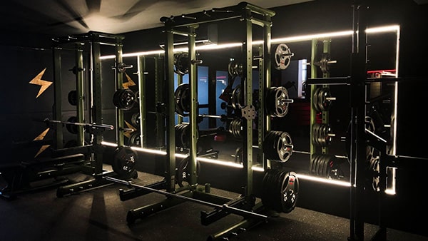 Une machine de musculation avec une barre et des poids dans la salle de sport Metabolik Montpellier.