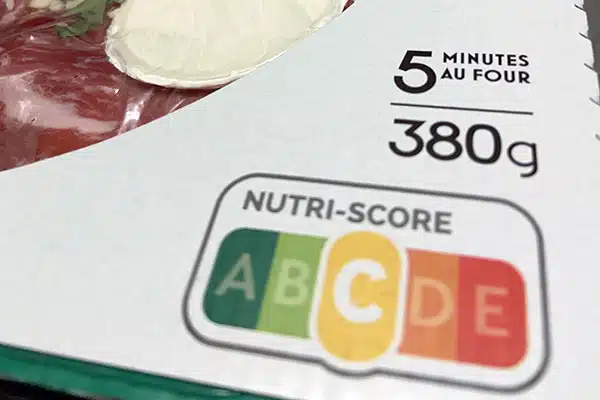 L'emballage alimentaire d'une pizza industrielle, avec le logo du Nutri-score classé sur la lettre C.
