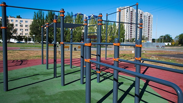 A street workout area with numerous horizontal and vertical bars for exercising.