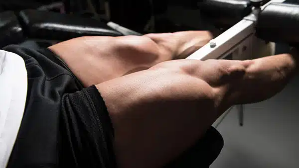 Les quadriceps d'un homme en bref qui réalise un exercice de musculation des cuisses dans une salle de fitness.