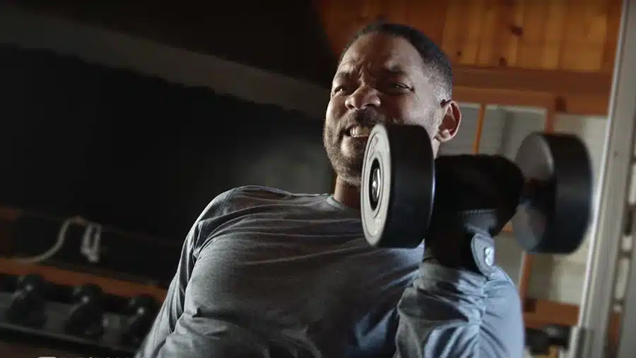 Un entraînement de Will Smith en musculation où ce dernier réalise l'exercice du curl biceps avec des haltères.