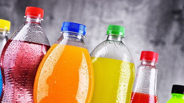 Bottles of colored sodas, rich in sugars and unhealthy.