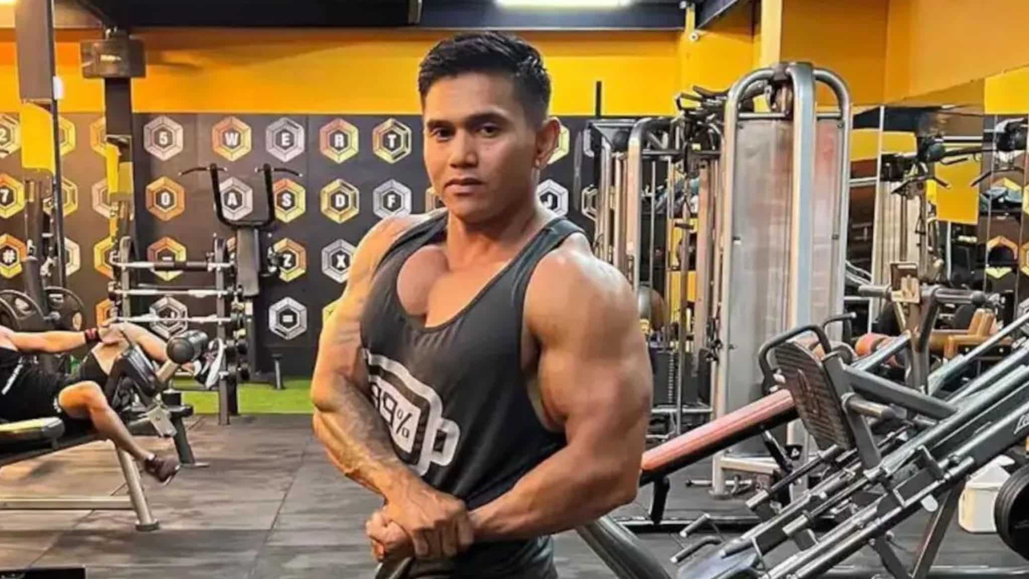 Young bodybuilder Justyn Vicky showing off his muscles in a weight room.