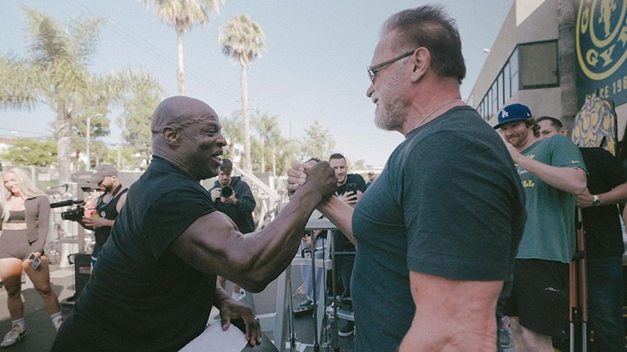 Ronnie Coleman and Arnold Schwarzenegger high-five during a workout at Gold's Gym in Venice Beach.