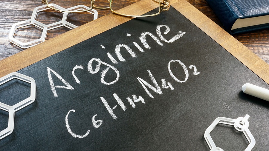 Un tableau noir avec écrit "Arginine" à la craie blanche, ainsi que la formule scientifique de cet acide aminé.