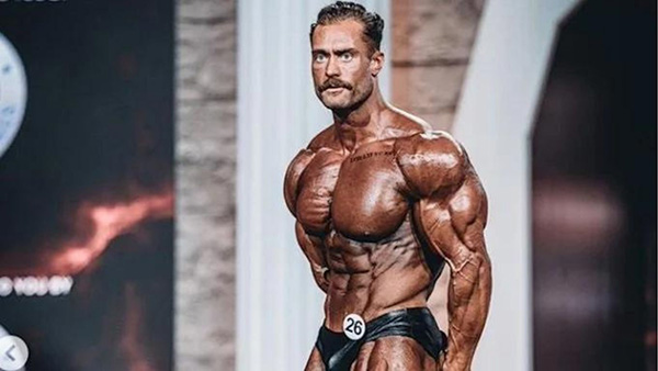 Canadian bodybuilder Chris Bumstead, shirtless on stage during a bodybuilding competition.