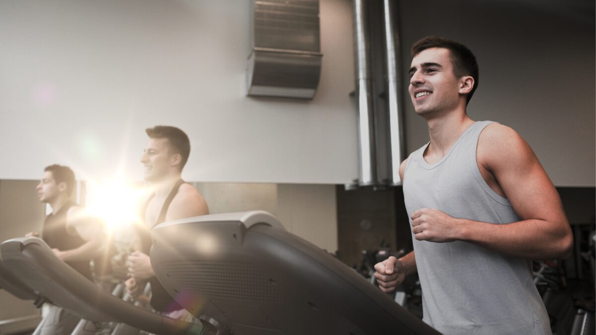 Des hommes en train de courir sur des tapis de course dans une salle de sport.