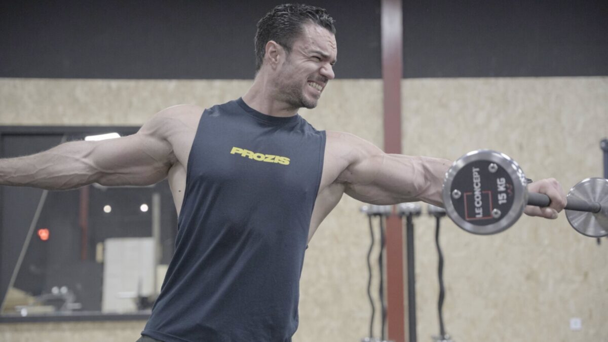 Le coach sportif Julien Quaglierini en train de faire un exercice de musculation dans une salle de fitness.